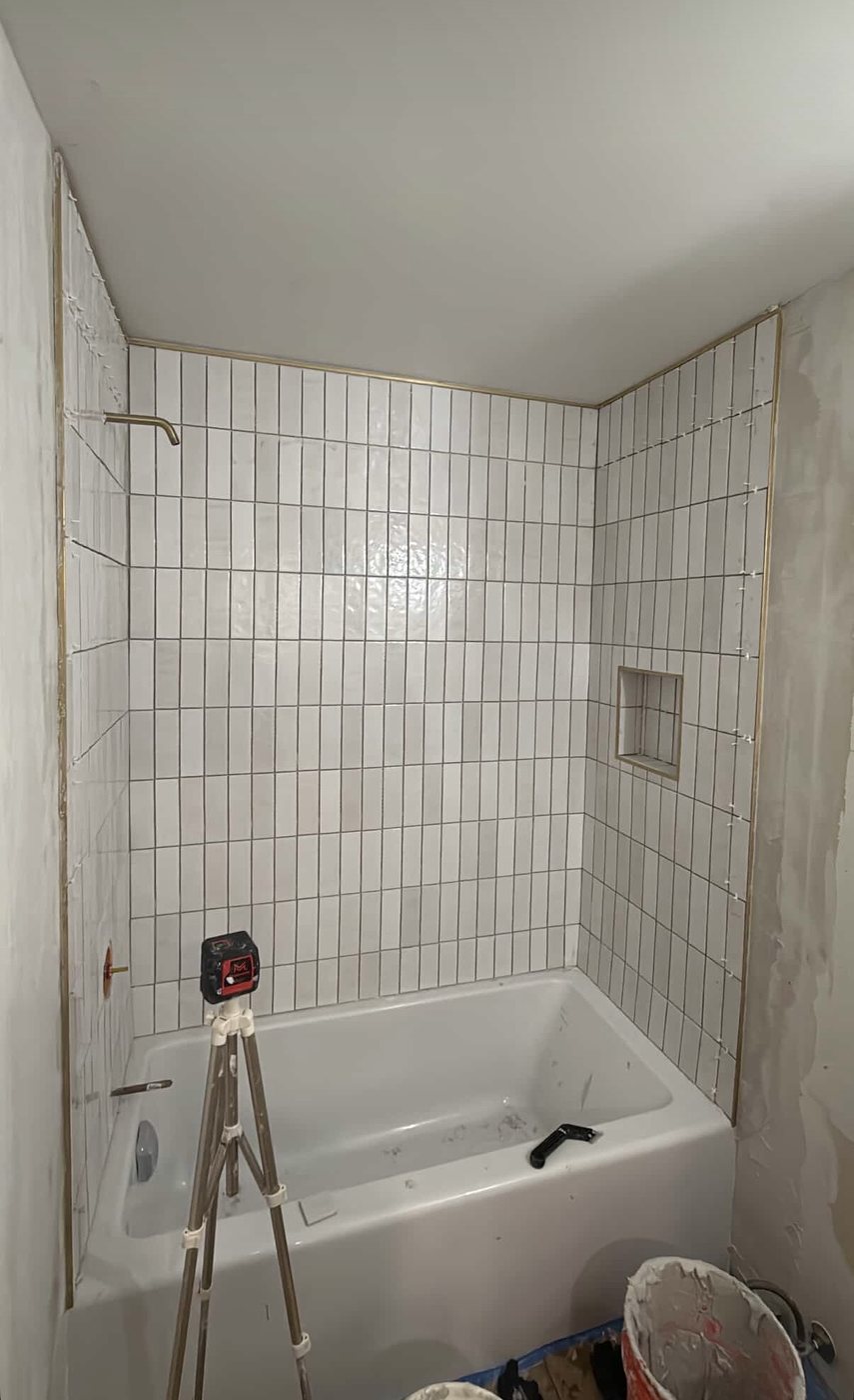 Finished bathroom with vertical white tile, brushed gold trim and fixtures